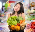 Young happy and beautiful Asian Chinese woman holding basket full of fresh vegetables and fruits smiling cheerful buying healthy Royalty Free Stock Photo