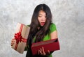 Young happy and beautiful Asian Chinese woman holding gift box receiving birthday or Christmas present opening the parcel excited Royalty Free Stock Photo