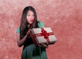 Young happy and beautiful Asian Chinese woman holding gift box receiving birthday or Christmas present opening the parcel excited Royalty Free Stock Photo