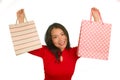 Young happy and beautiful Asian Chinese woman in red dress smiling cheerful holding shopping bags as excited shopaholic girl Royalty Free Stock Photo