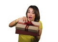 Young happy and beautiful Asian Indonesian woman opening Christmas or birthday gift box with red ribbon excited and cheerful Royalty Free Stock Photo