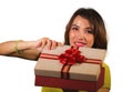 Young happy and beautiful Asian Indonesian woman opening Christmas or birthday gift box with red ribbon excited and cheerful Royalty Free Stock Photo