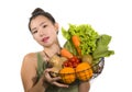 Young happy and beautiful Asian Japanese woman holding basket full of fresh vegetables and fruits smiling cheerful  in healthy Royalty Free Stock Photo