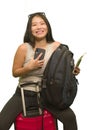 Young happy and beautiful Asian Korean woman carrying suitcase holding passport and mobile phone ready for holidays trip smiling Royalty Free Stock Photo