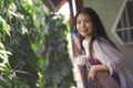 Young happy and beautiful Asian Korean woman having morning coffee or tea at hotel terrace or home balcony leaning on the Royalty Free Stock Photo