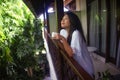 Young happy and beautiful Asian Korean woman having morning coffee or tea at hotel terrace or home balcony leaning on the Royalty Free Stock Photo