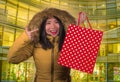 Young happy and beautiful Asian Korean woman holding shopping bag buying Christmas present in city mall smiling excited and Royalty Free Stock Photo
