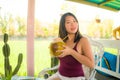 Young happy and beautiful Asian Korean woman holding young coconut drink outdoors smiling cheerful enjoying the coco water during