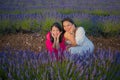 Young happy and beautiful Asian korean woman playing on lavender flowers field with her hispanic girlfriend enjoying sweet