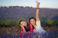 Young happy and beautiful Asian korean woman playing on lavender flowers field with her hispanic girlfriend enjoying sweet