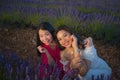 Young happy and beautiful Asian korean woman playing on lavender flowers field with her hispanic girlfriend enjoying sweet