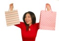 Young happy and beautiful Asian Korean woman in red dress smiling cheerful holding shopping bags as excited shopaholic girl Royalty Free Stock Photo