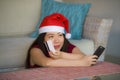 Young happy and beautiful Asian Korean woman in Santa Claus hat holding credit card using mobile phone for Christmas online shoppi Royalty Free Stock Photo