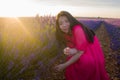 Young happy and beautiful Asian Korean woman in Summer dress enjoying free and playful in romantic and lovely purple lavender