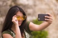 Young happy and beautiful Asian Korean woman taking selfie photo with mobile phone posing playful and carefree in hipster Royalty Free Stock Photo