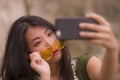 Young happy and beautiful Asian Korean woman taking selfie photo with mobile phone posing playful and carefree in hipster Royalty Free Stock Photo