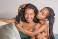 Young happy and beautiful Asian sisters or girlfriends couple smiling cheerful taking selfie photo with mobile phone at home
