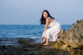 Young happy and beautiful Asian woman by the sea - Attractive Korean girl in white dress enjoying relaxed summer holidays at Royalty Free Stock Photo