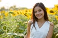 Young happy beautiful Asian woman smiling in the field of bloomi Royalty Free Stock Photo