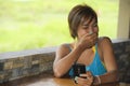 Young happy beautiful and attractive Asian woman sitting in coffee shop using internet app on mobile phone laughing excited outdoo Royalty Free Stock Photo