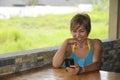 Young happy beautiful and attractive Asian woman sitting in coffee shop using internet app on mobile phone laughing excited outdoo Royalty Free Stock Photo