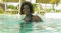 Happy and beautiful black African American woman in bikini having fun at tropical beach resort swimming pool relaxed and playful Royalty Free Stock Photo