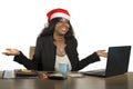 Young happy and beautiful black afro American business woman in Santa Christmas hat working at office computer desk smiling succes Royalty Free Stock Photo