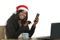 Young happy and beautiful black afro American business woman in Santa Christmas hat working at office computer desk smiling succes Royalty Free Stock Photo