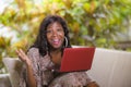 Young happy and beautiful black afro American woman in fashionable dress and working with laptop computer enjoying freelance Royalty Free Stock Photo