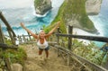 Young happy and beautiful blond woman smiling cheerful at tropical beach cliff landscape enjoying Summer holidays getaway carefree Royalty Free Stock Photo