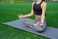 Young happy and beautiful brunette girl doing yoga workout in park, sitting in lotus pose meditating enjoying retreat in balance a Royalty Free Stock Photo