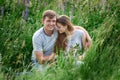 Young happy beautiful couple sitting in green meadow Royalty Free Stock Photo