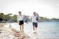 Young happy beautiful family walking together on the beach enjoying summer holidays Royalty Free Stock Photo