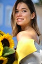 Young happy beautiful girl is walking in dress with a bouquet of sunflowers on a city street. Autumn concept Royalty Free Stock Photo