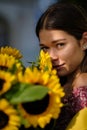 Young happy beautiful girl is walking in dress with a bouquet of sunflowers on a city street. Autumn concept Royalty Free Stock Photo