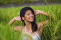 Young happy and beautiful hispanic woman smiling playful having fun posing sexy isolated on green rice field in Asia tourist trip Royalty Free Stock Photo