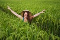 Young happy and beautiful red hair woman in traditional Asian farmer hat smiling cheerful isolated on green rice field in Asia Royalty Free Stock Photo