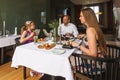 Young happy beautiful smiling Caucasian family of father, mother and daughter enjoying dinner together by served restaurant table Royalty Free Stock Photo
