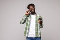 Young happy black African man smiling while holding coffee cup and talking on mobile phone against white background Royalty Free Stock Photo