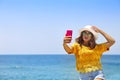 Young happy blond woman taking selfie portrait with mobile phone at beautiful tropical paradise view of ocean enjoying summer Royalty Free Stock Photo