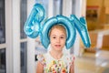 Young happy blonde girl with baloons smiling close up, lifestyle real people concept. Baloons shaped letters boy on the head of Royalty Free Stock Photo