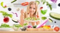 Young happy blonde girl eating healthy salad from arugula spinach tomatoes olives onion and olive oil Healthy vegetable concept Royalty Free Stock Photo