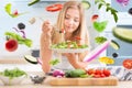 Young happy blonde girl eating healthy salad from arugula spinach tomatoes olives onion and olive oil. Healthy vegetable concept