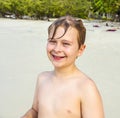 Young happy boy with brown wet hair is smiling and enjoying the beach Royalty Free Stock Photo