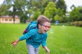 Young happy boy running in the grass at the park on a summer day Royalty Free Stock Photo