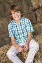 Young Happy Boy Sitting Smiling on Hay Bales Royalty Free Stock Photo