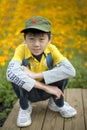 Young happy boy squatting at field of flowers Royalty Free Stock Photo