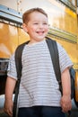 Young happy boy waits to board bus for school Royalty Free Stock Photo