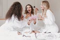 Young happy bride and bridesmaids 20s wearing housecoat drinking