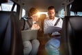 Happy business colleagues working on computer in the car Royalty Free Stock Photo